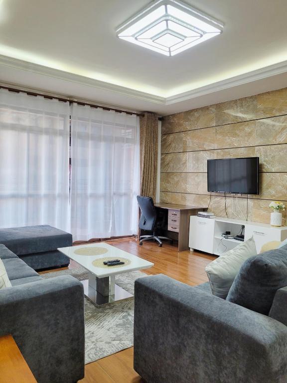 内罗毕Stunning and serene homes的客厅配有两张沙发和一台电视机