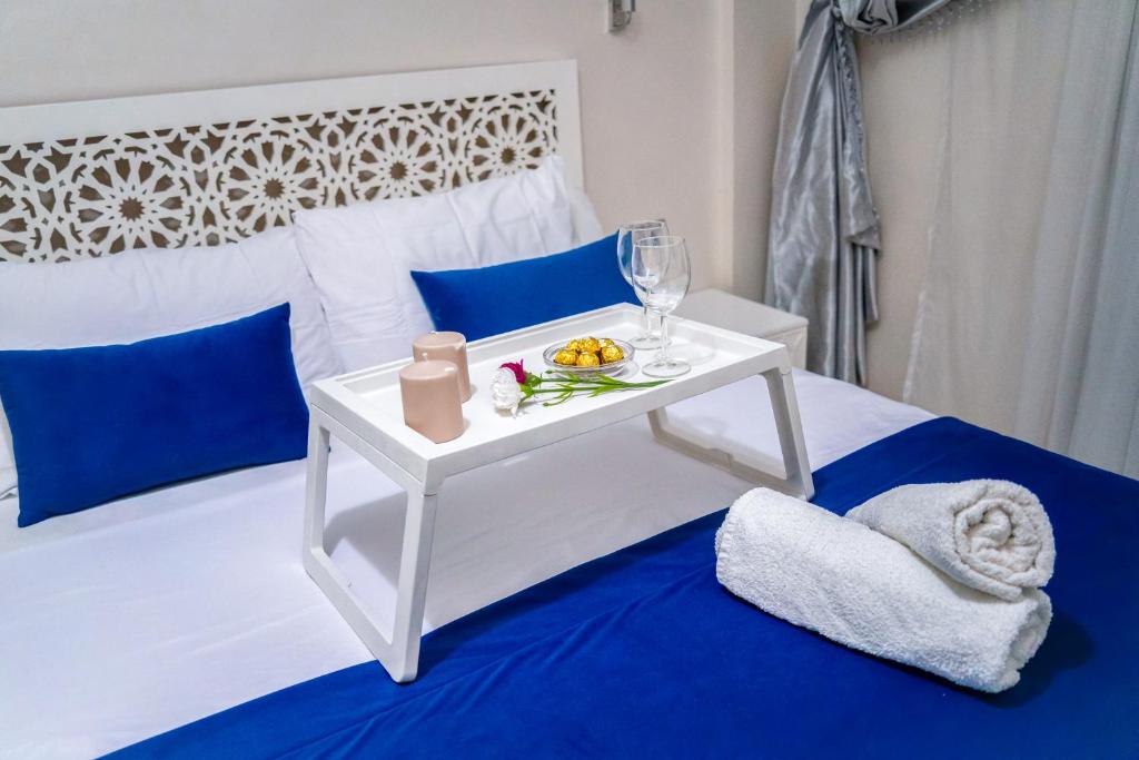 丹吉尔Apartment for rent with 2 bedrooms的一张白色的床,上面有一张带果盘的白色桌子