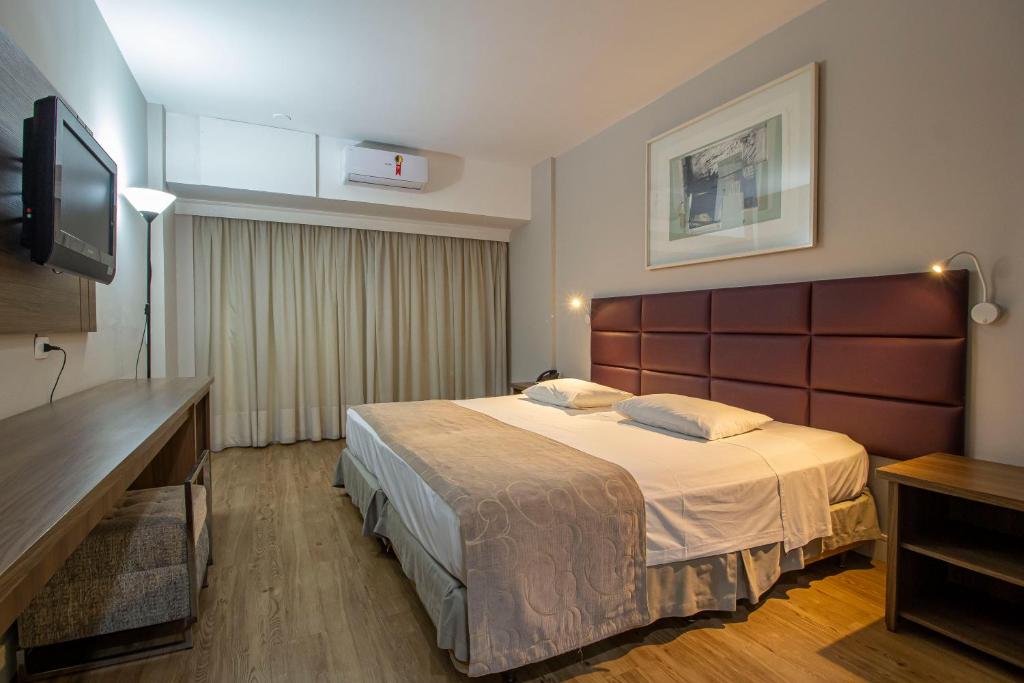 库里提巴Hotel Victoria Villa Curitiba by Nacional Inn的配有一张床和一台平面电视的酒店客房