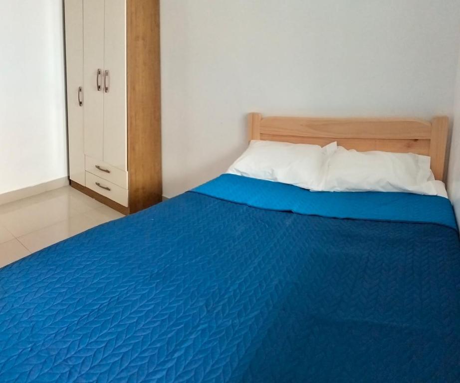 皮斯科Airbnb Paracas Inn的一间卧室配有一张蓝色的床和木制床头板