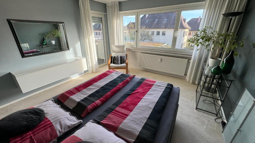 伯布林根Monikas Home - Gemütliche 3-Zimmer-Wohnung im Herzen von Böblingen的一间卧室配有一张床,床上有条纹毯子