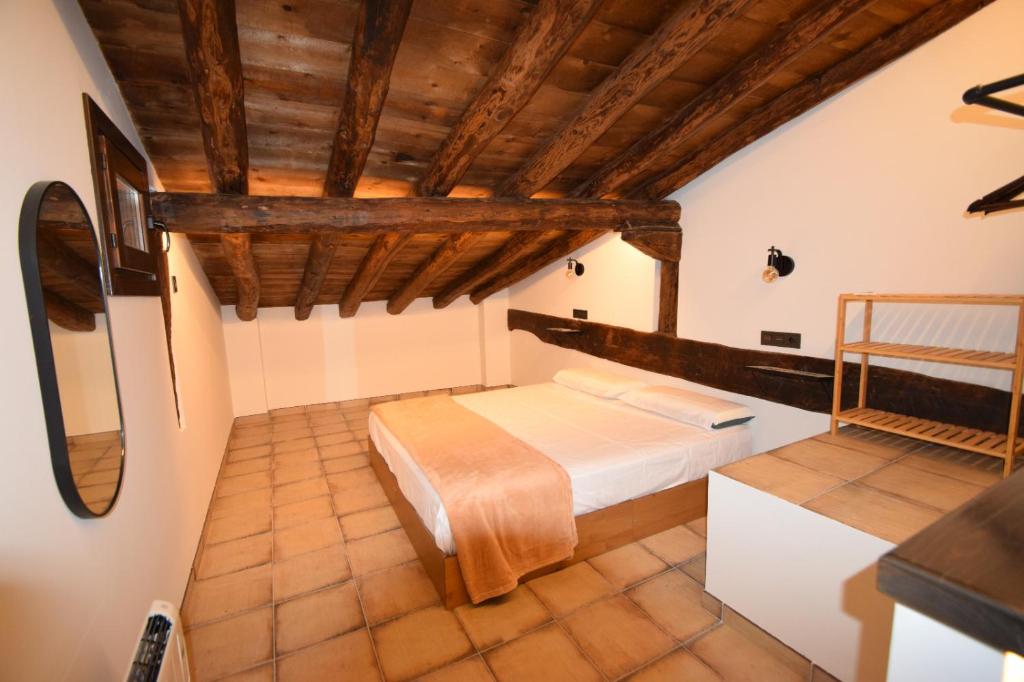 阿尔巴拉辛La Botica的一间带一张床的卧室,位于带木制天花板的房间内