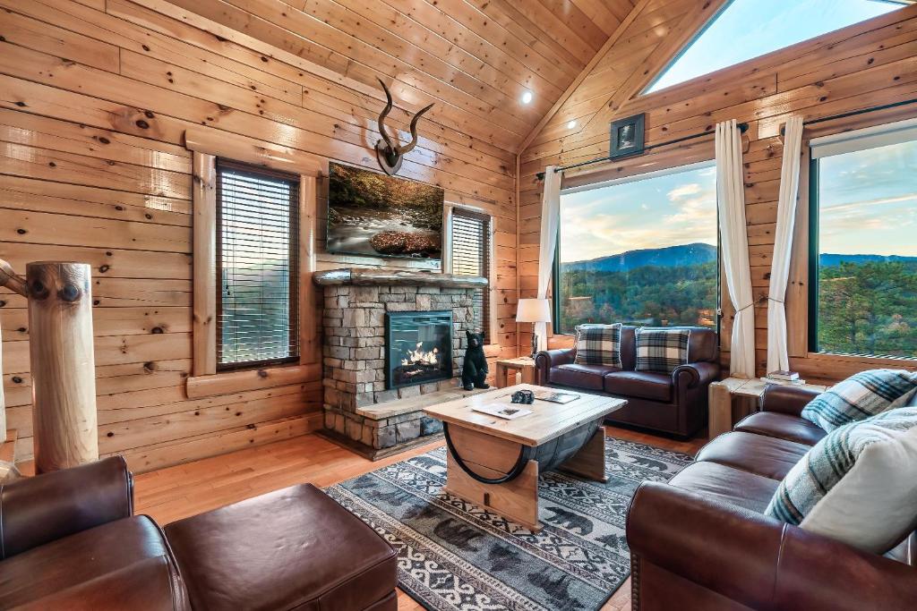 赛维尔维尔Epic Mountain Views, Hot Tub, Game Room, Sleeps 10的客厅设有壁炉和皮革家具。