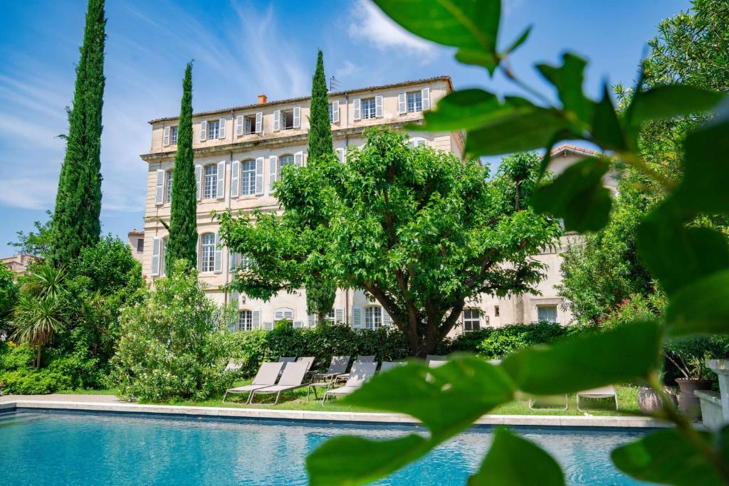 马藏Château de Mazan, BW Premier Collection by Best Western的一座带游泳池和树木的大型建筑