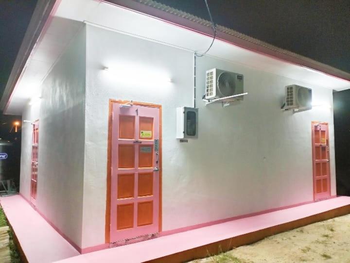 瓜拉丁加奴Chalet Roomstay Mini Private Pool,Penginapan Teratak KandaMus的白色的建筑,设有红色的门和风扇