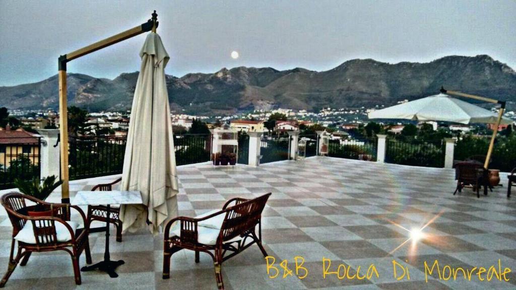 蒙雷亚莱罗卡迪蒙雷亚莱酒店的庭院配有桌椅和遮阳伞。
