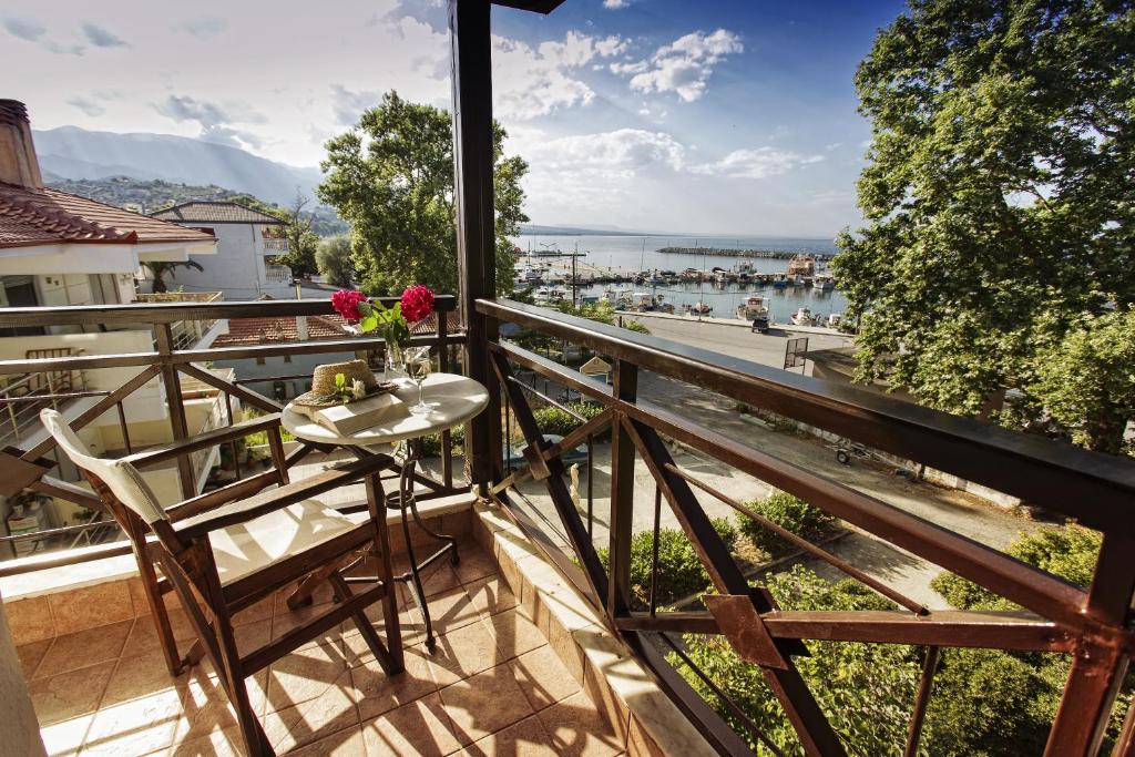 帕拉塔蒙Hotel Morfeas的阳台配有桌椅,享有水景。