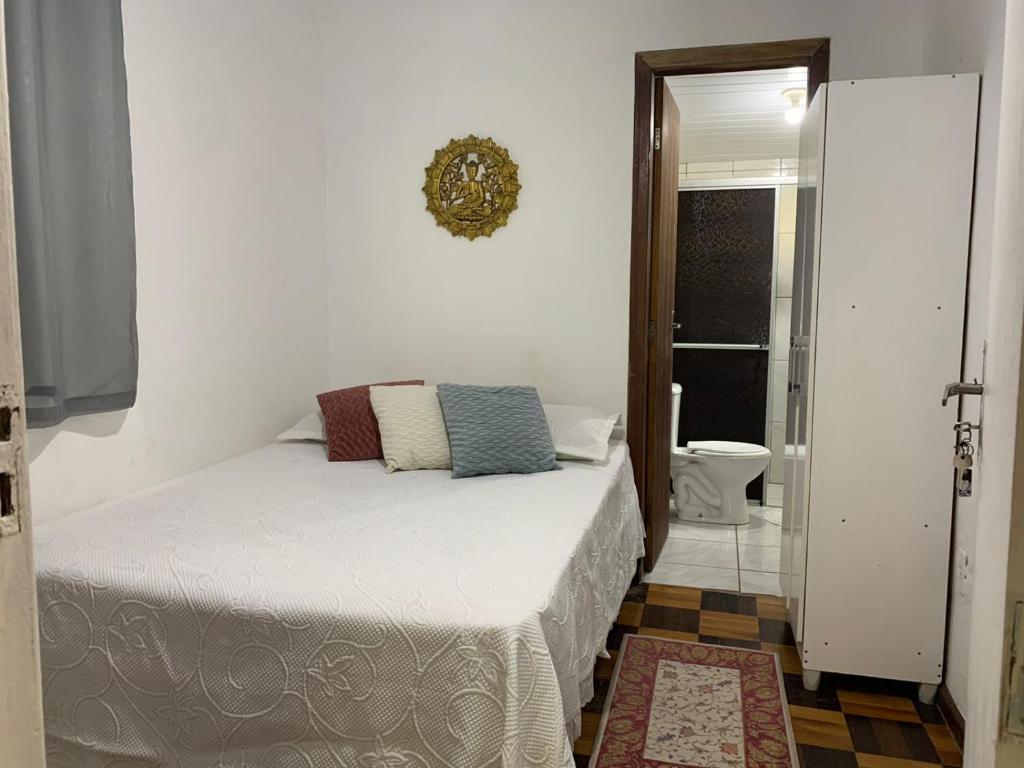 弗洛里亚诺波利斯Floripa Camping e Hostel的一间卧室配有一张床,浴室设有卫生间