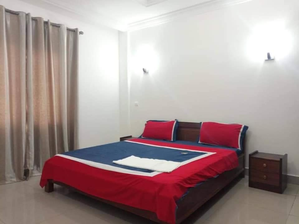 黑角Appartement bord de mer的一间卧室配有红色和蓝色床单