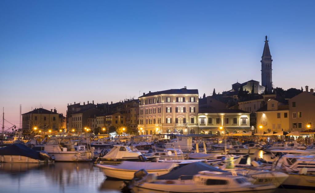 罗维尼Adriatic Hotel by Maistra Collection的一群船在晚上停靠在港口
