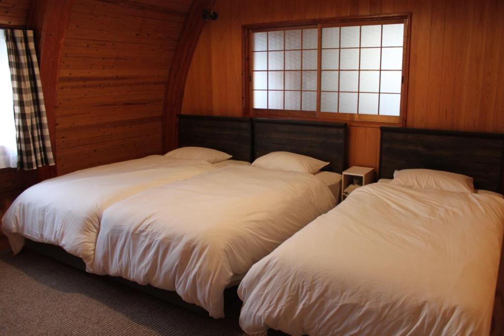 桑名市Nagashima cottage - Vacation STAY 9014的带2扇窗户的客房内的2张床