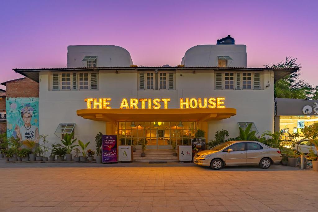 乌代浦The Artist House Udaipur的前面有停车位的建筑