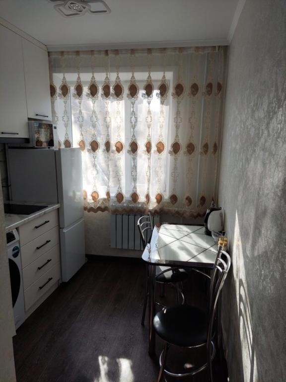 卡拉甘达Квартира的一个带桌子和窗户的小厨房
