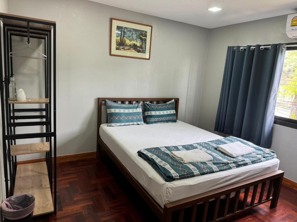 佛丕Chill @ Phetchaburi的一间卧室配有蓝色窗帘的床