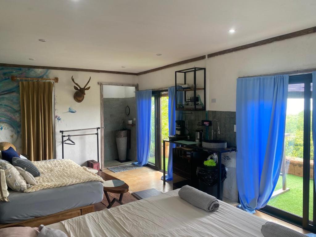TorioSea view hills bungalow的一间卧室设有两张床和蓝色窗帘