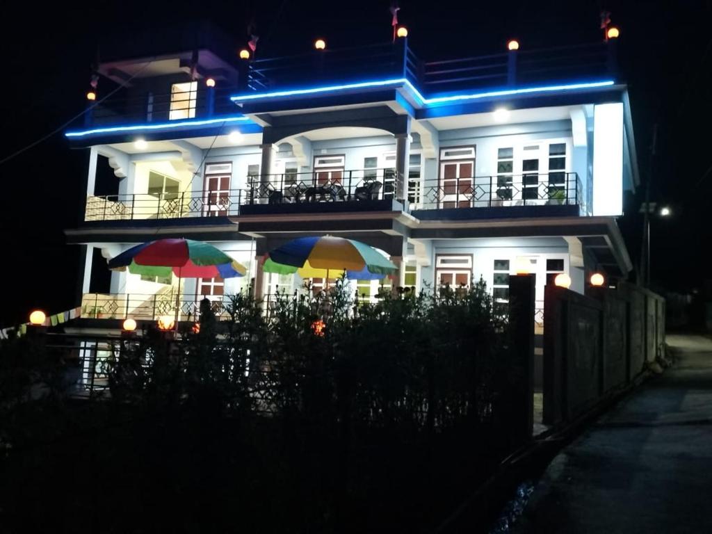 大吉岭Darjeeling View Homestay的夜晚在房子前面有两把遮阳伞