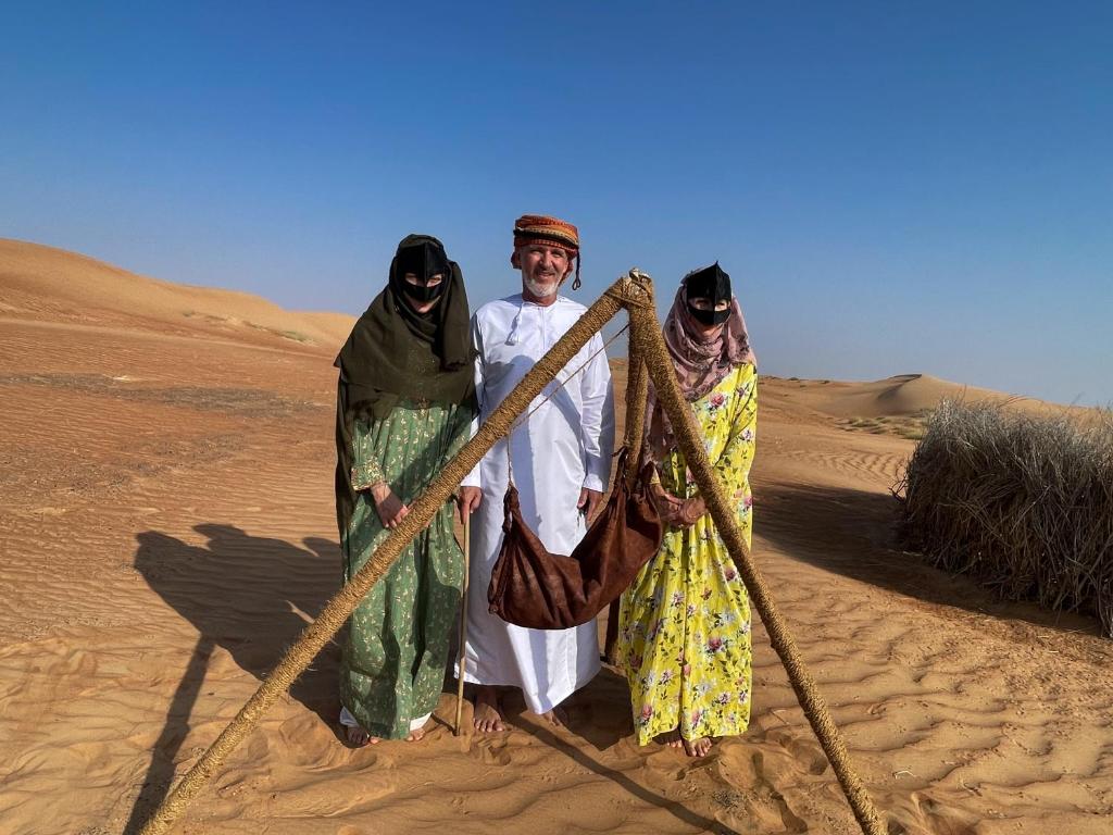 Muntaribwahiba Bedouiens privae Camp的一群站在沙漠中的三人