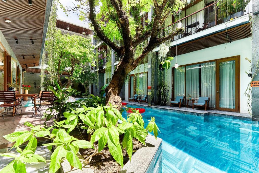 岘港潭屋别墅酒店 的一座游泳池,旁边是一座建筑物