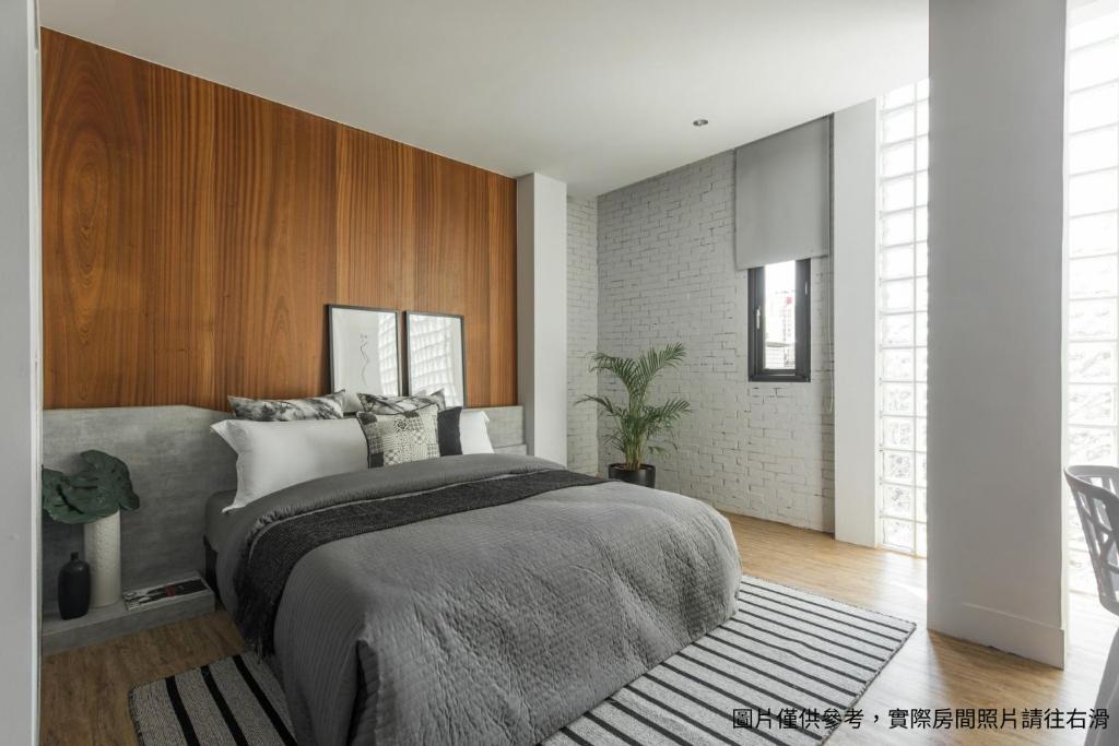 彰化市H suite Go的一间卧室设有一张大床和木墙