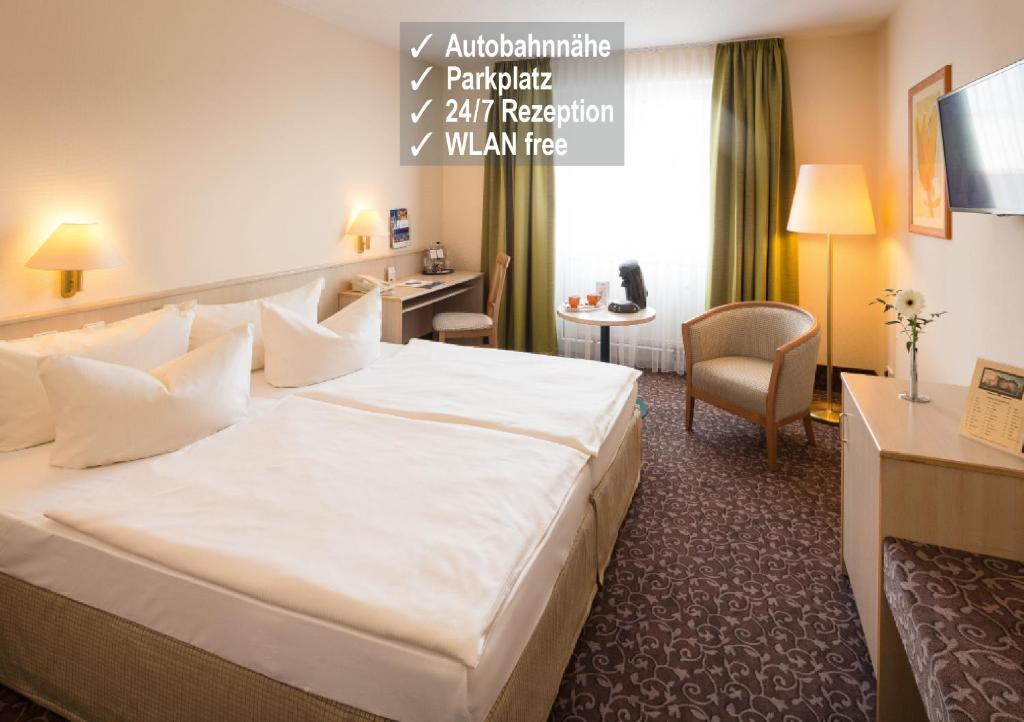 开姆尼茨开姆尼茨公园琥珀酒店的一间酒店客房,房间内设有一张白色大床