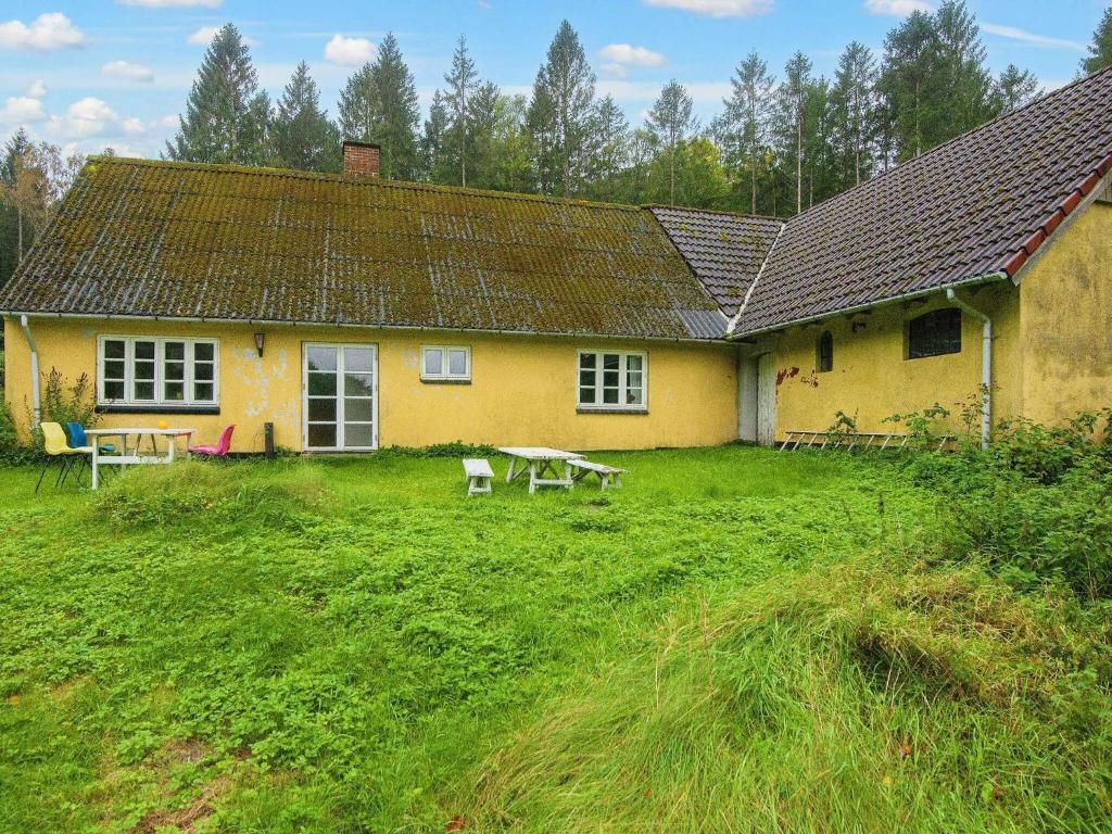 斯坎讷堡5 person holiday home in Skanderborg的黄色的房子,前面设有野餐桌