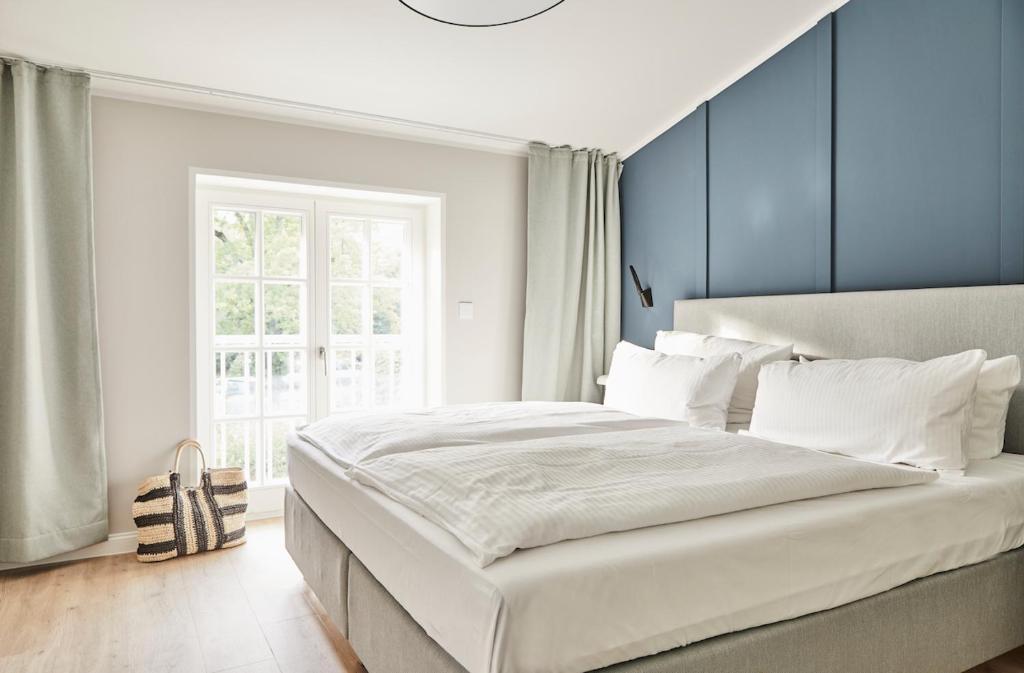普雷罗Strandglück Prerow的卧室配有白色大床和蓝色的墙壁