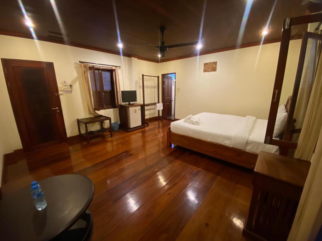 琅勃拉邦somvang khily guesthouse 宋旺吉利 酒店的一间设有床铺和桌子的房间