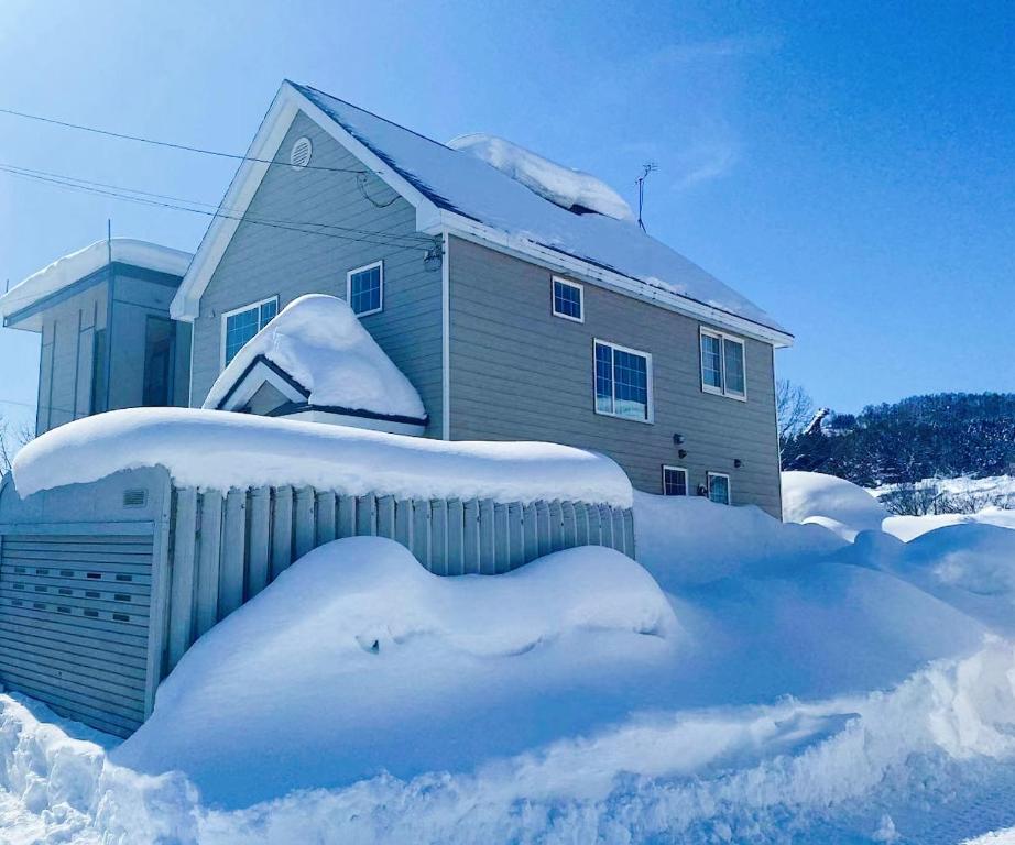 俱知安町Niseko Powder fox的雪覆盖着栅栏的房子