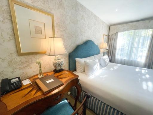开普敦安德罗斯精品酒店的一间卧室配有一张床和一张书桌及电话
