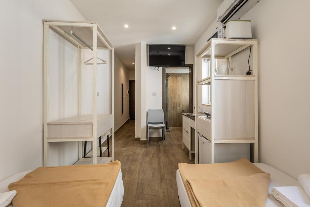 帕切维拉Studio 44 with twin beds & kitchenette at the new Olo living的宿舍间设有两张床和厨房。