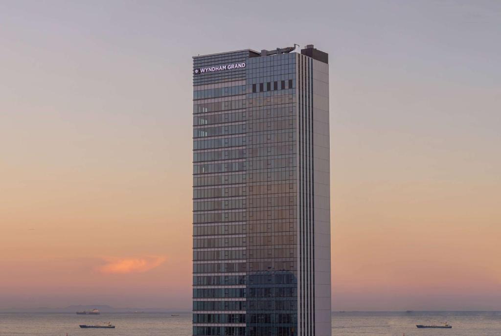 釜山Wyndham Grand Busan的一座高大的海洋建筑,享有日落美景