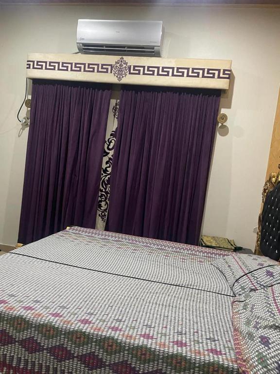 GujrātWarraich villa gt raod gujrat entire的一间卧室配有一张床,楼上配有空调