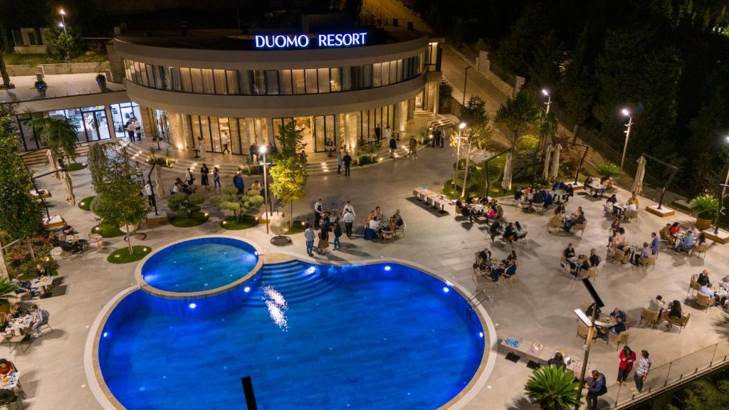斯库台Duomo Resort的大楼前方大型蓝色泳池的顶部景色