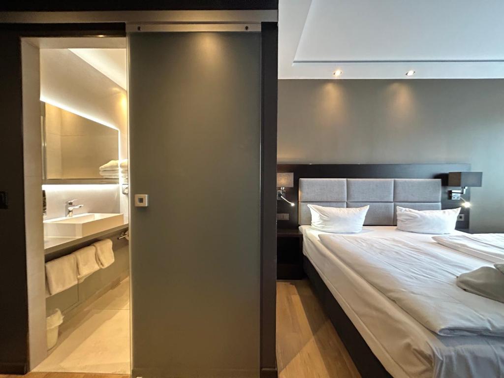 卡尔斯鲁厄卡尔门酒店的一间卧室设有一张大床和一个水槽