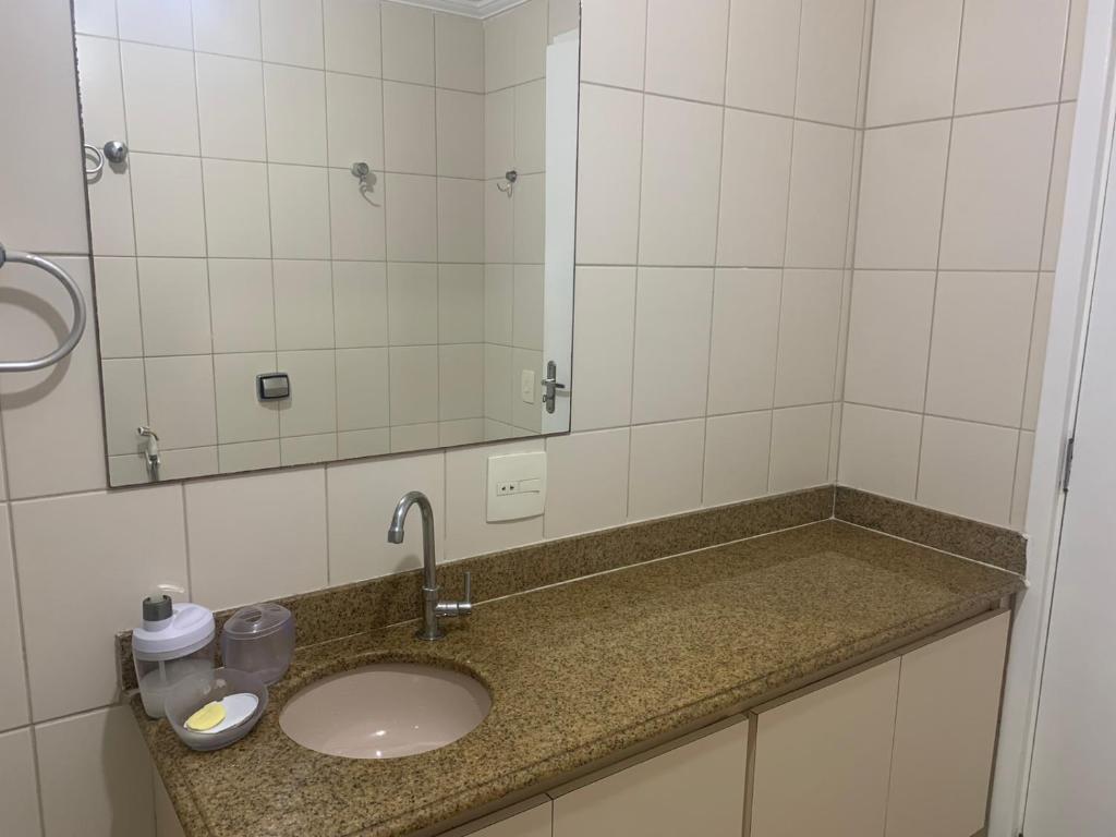 瓜鲁雅Apartamento Astúrias a menos de 50m da praia的浴室的柜台设有水槽和镜子