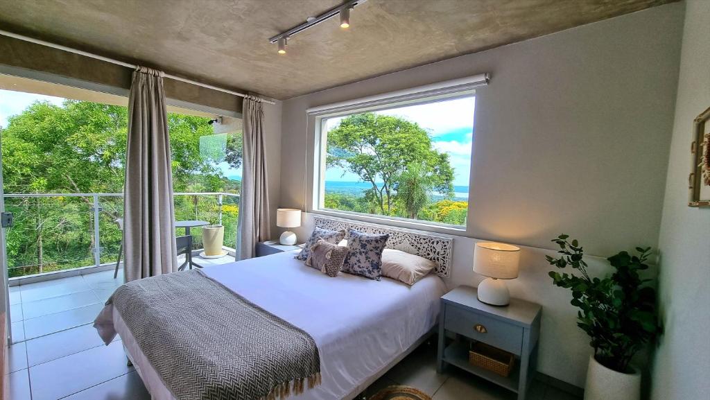 圣贝纳迪诺Lasuiza Suites的一间卧室设有一张床和一个大窗户