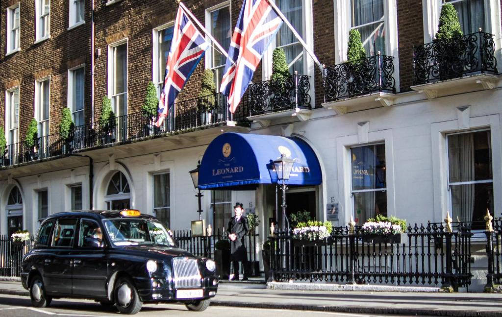 伦敦里奥纳德酒店的一辆旧车驶过一座有英国国旗的建筑