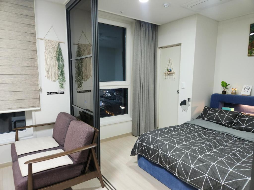 束草市The Mark Sokcho Residence Hotel #15F的卧室配有床、椅子和窗户。