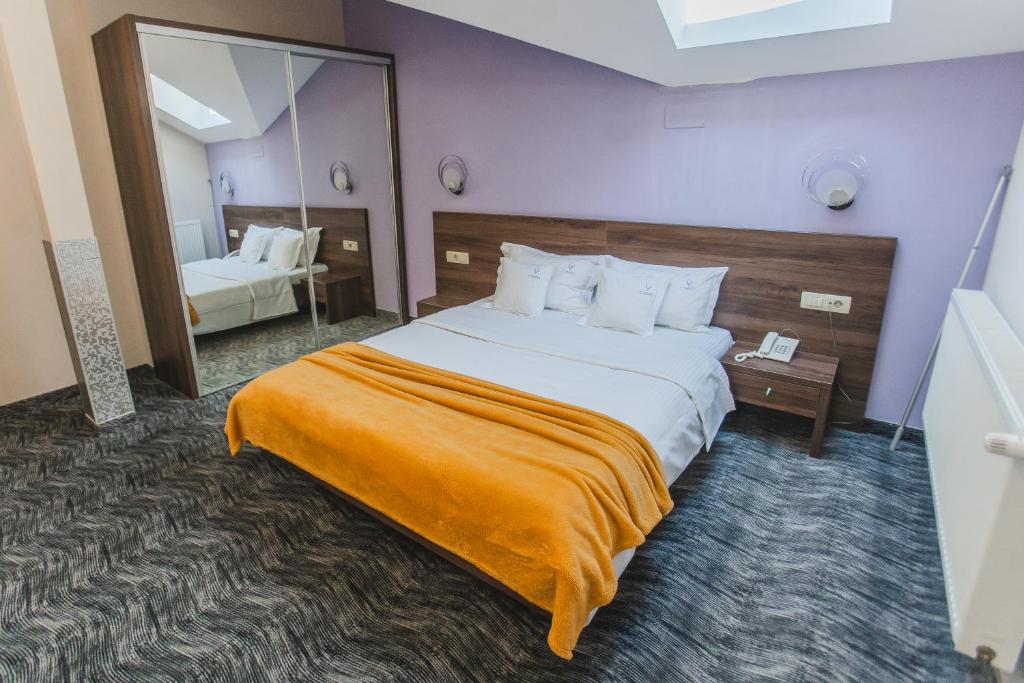 奥拉迪亚卡罗精品酒店的配有一张大床和镜子的酒店客房