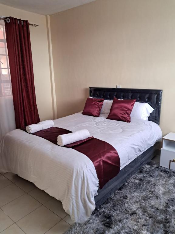 马查科斯Tirisi Homes的一间卧室配有一张带红色枕头的大床