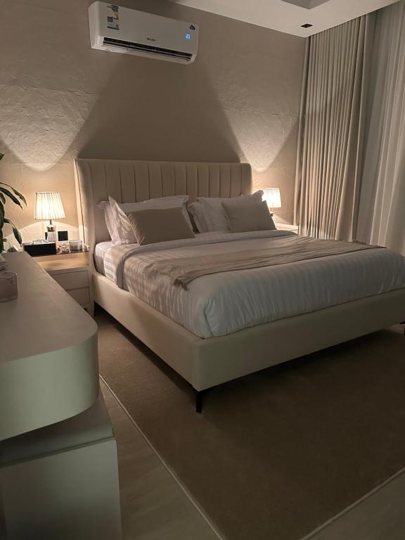 利雅德Three Bedroom furnished apartment in north Riyadh的一间卧室配有一张带两盏灯的大型白色床。