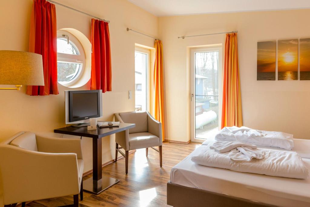 EldenburgFleesensee 02的酒店客房配有一张床和一张书桌及一台电视