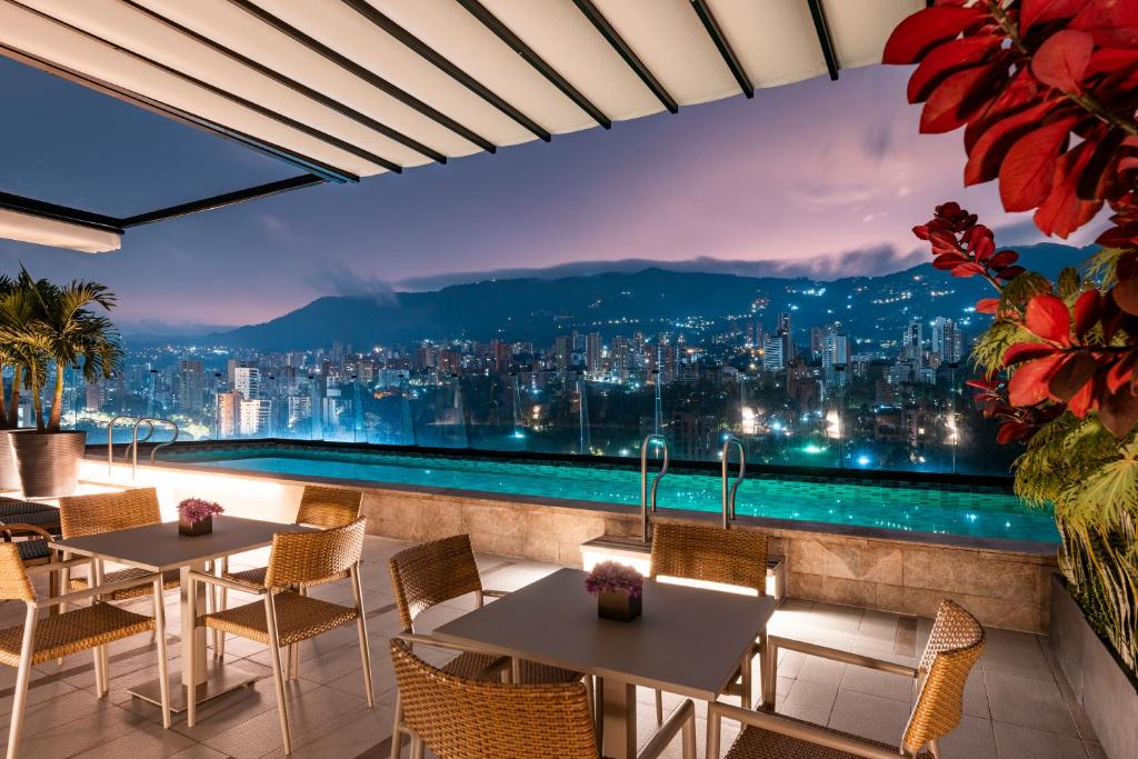 麦德林Hotel York Luxury Suites Medellin by Preferred的晚上享有城市美景的餐厅