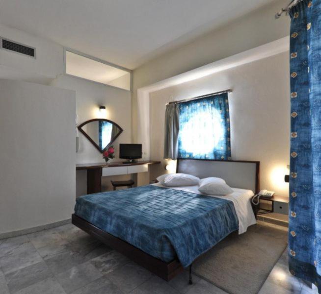 干尼亚罗登酒店的一间卧室配有一张床、一张书桌和一个窗户。