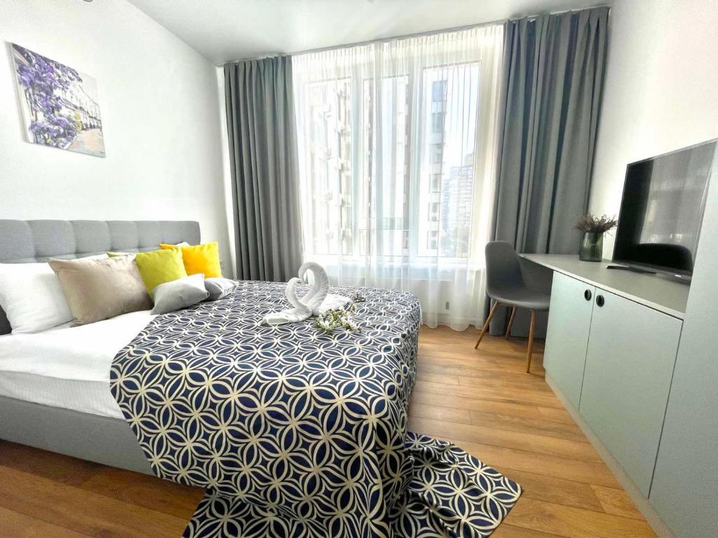 基辅Люкс апартаменти в затишному ЖК бізнес класу的酒店客房配有一张床、一张书桌和一台电视。