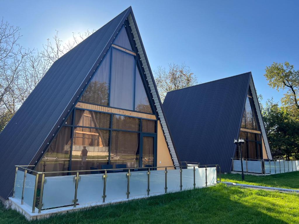 TopçuTopchu Forest Ismayilli的一座带三角形屋顶和玻璃的房屋