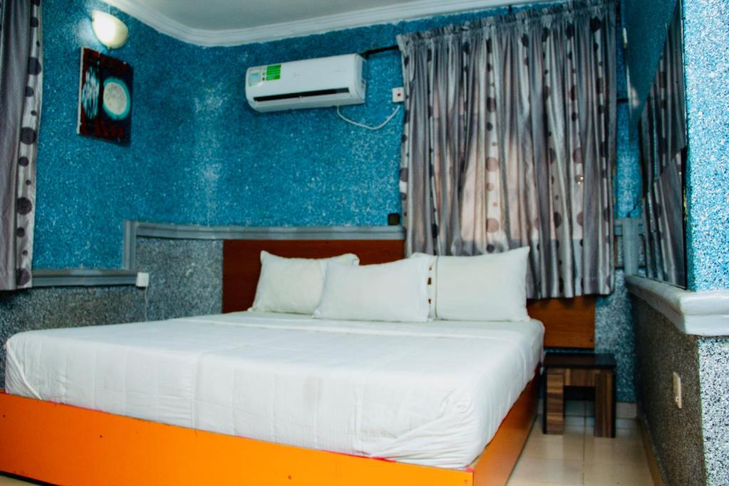 伊凯贾Double One Suites & Lodge的一间卧室配有一张蓝色墙壁的床