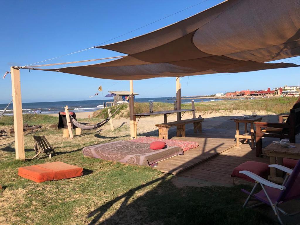 凯博波洛尼奥La Pequeña Hostel的海滩上带沙箱和遮阳伞的天井
