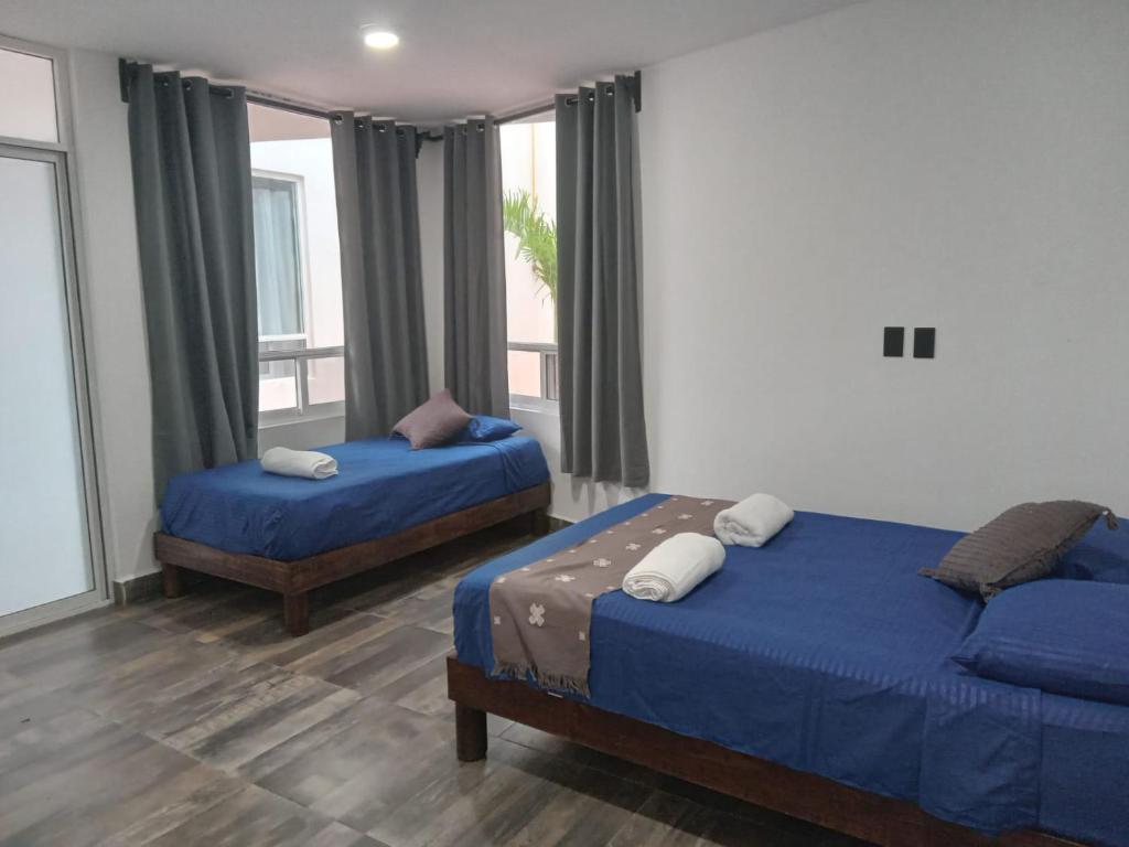 坎昆Villas Carlota Cancún的一间卧室设有两张床和窗户。