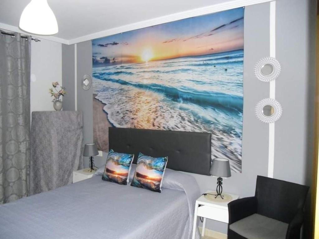 托雷德尔马尔Atalaya del Mar的一间卧室,配有一幅大幅海洋画